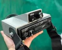 Pioneer Head Unit - Single-DIN, mechanical buttons, black bezel, silver casing with strap - Compact design with prominent volume knob and button layout.
